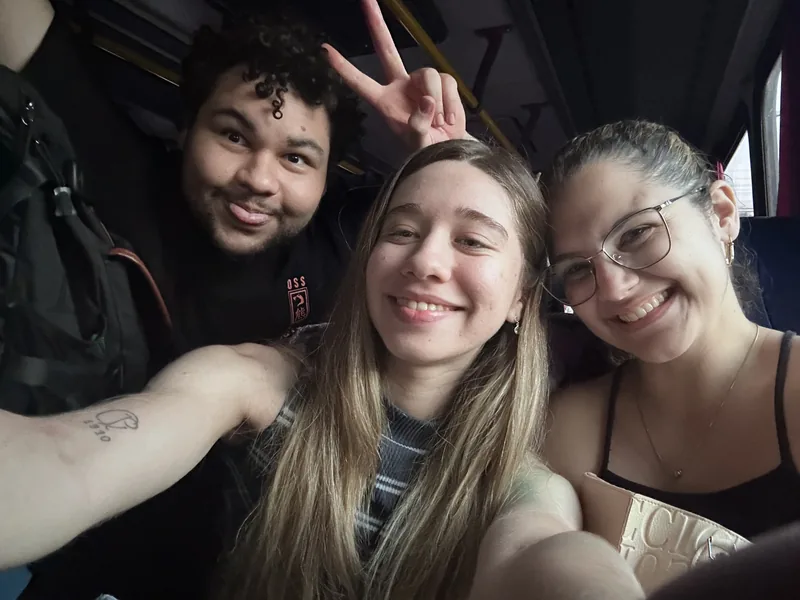 Uma selfie de três amigos durante uma viagem.